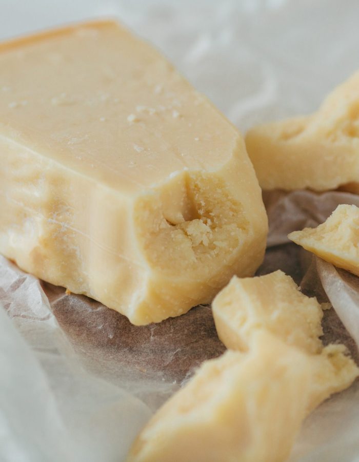 Parmesan cheese. Delicious italian parmesan cheese on white parchment. Pieces of Parmesan cheese